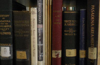 A row of research books on a shelf in a library.