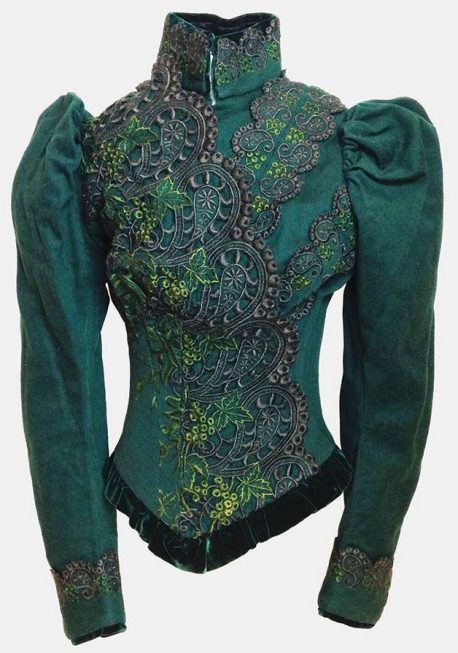 A green jacket with lace and embroidery.