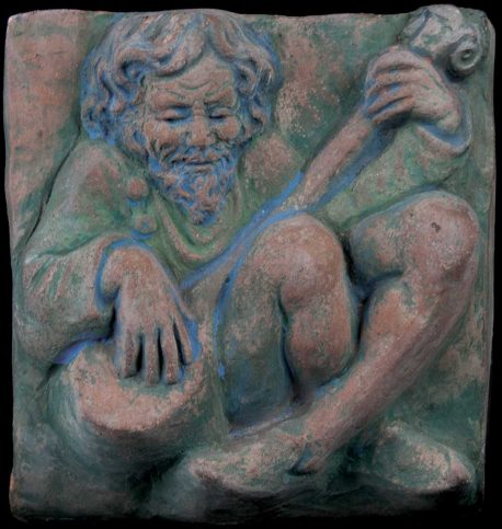 A ceramic tile depicting a man playing a guitar.