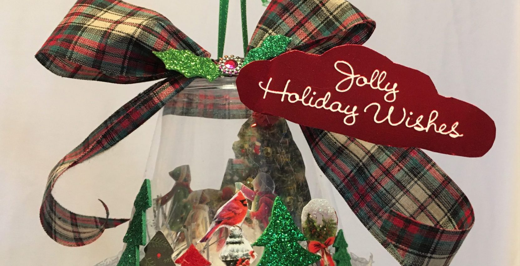 A glass ornament with a christmas tree in it.