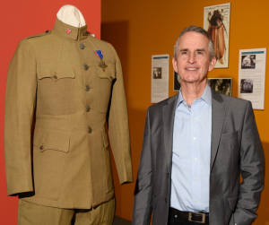 A man in a suit standing next to a mannequin.
