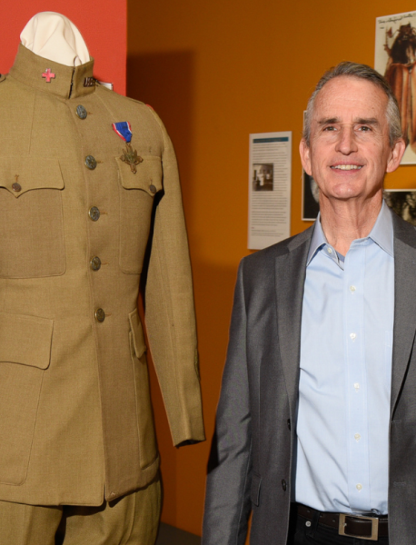A man in a suit standing next to a mannequin.