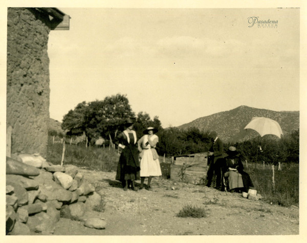 In this photograph, circa 1917-1920, Eva's daughter Leonora Muse Curtin and Leonora's daughter, also named Leonora, stand left. Adalbert stands behind Eva who sits near her umbrella sketching an unidentified adobe structure. Eva and Adalbert, who was an entomologist as well as a physician, conducted their fieldwork together, he collecting insects of the order Coleoptera and she painting. Together they combed California looking for adobes and beetles. (Fényes Papers, FCP.63.10)