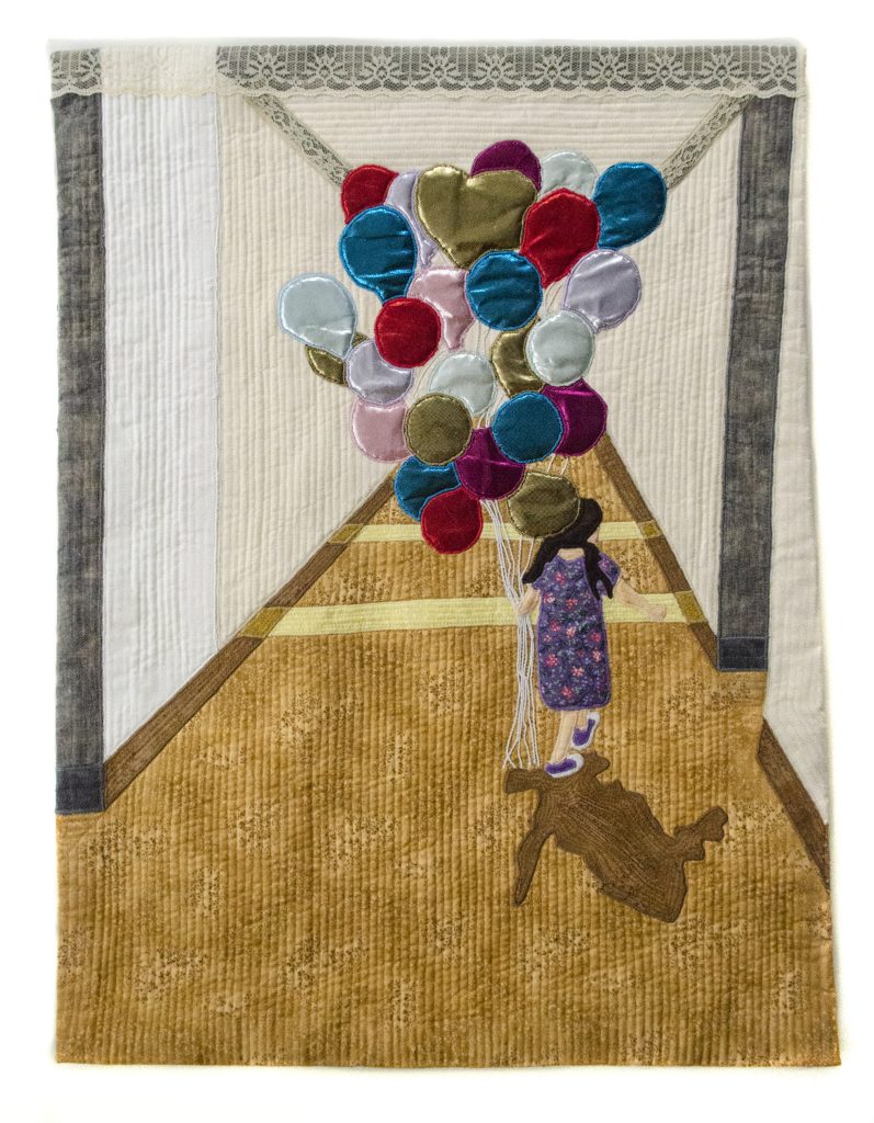 a quilt depicting a child holding a bunch of balloons