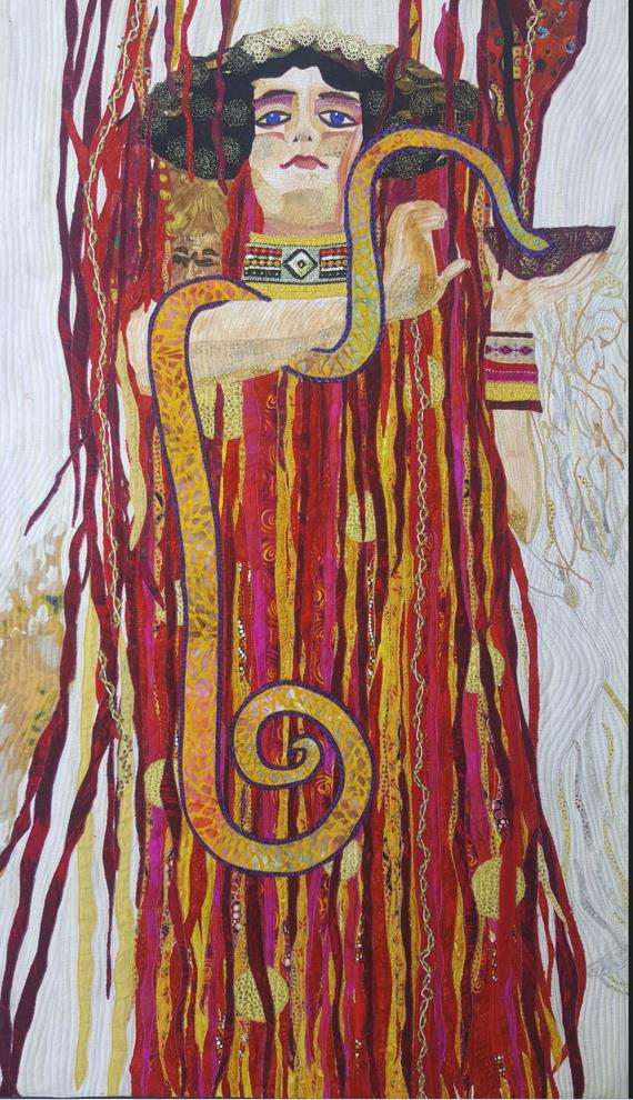 a quilt depicting a woman wearing red and holding a snake