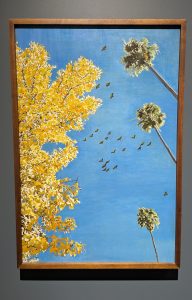 A painting of parrots flying through a blue sky between a yellow tree and tall palm trees